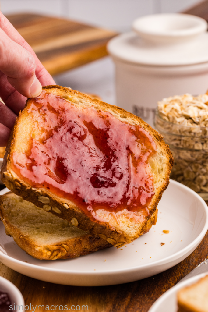 Oatmeal bread slathered with jam, ready to serve. 
