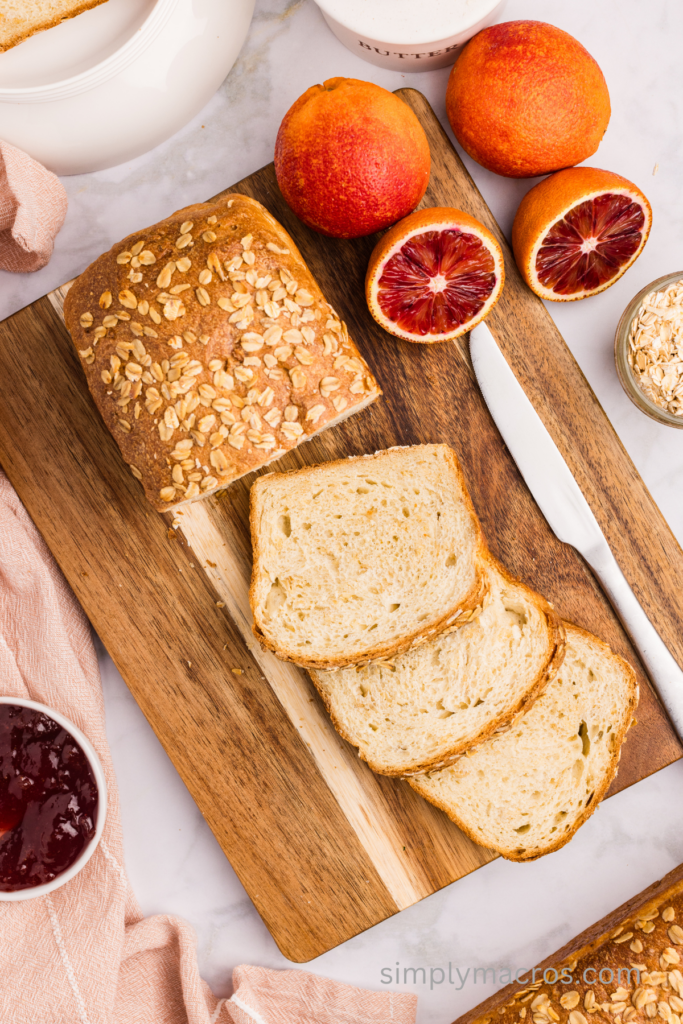 Oatmeal bread on a cutting board, sliced and ready to serve.