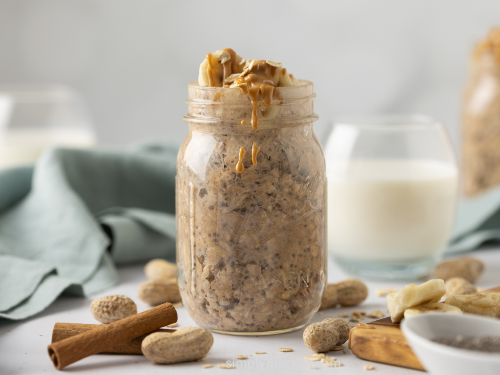 Overnight oats made with peanut butter and banana on a table with a glass of milk in the background.