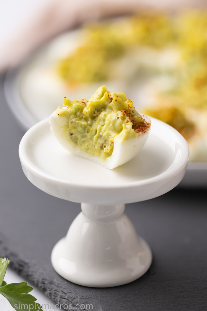 Close up photo of a bite missing from an avocado deviled egg.
