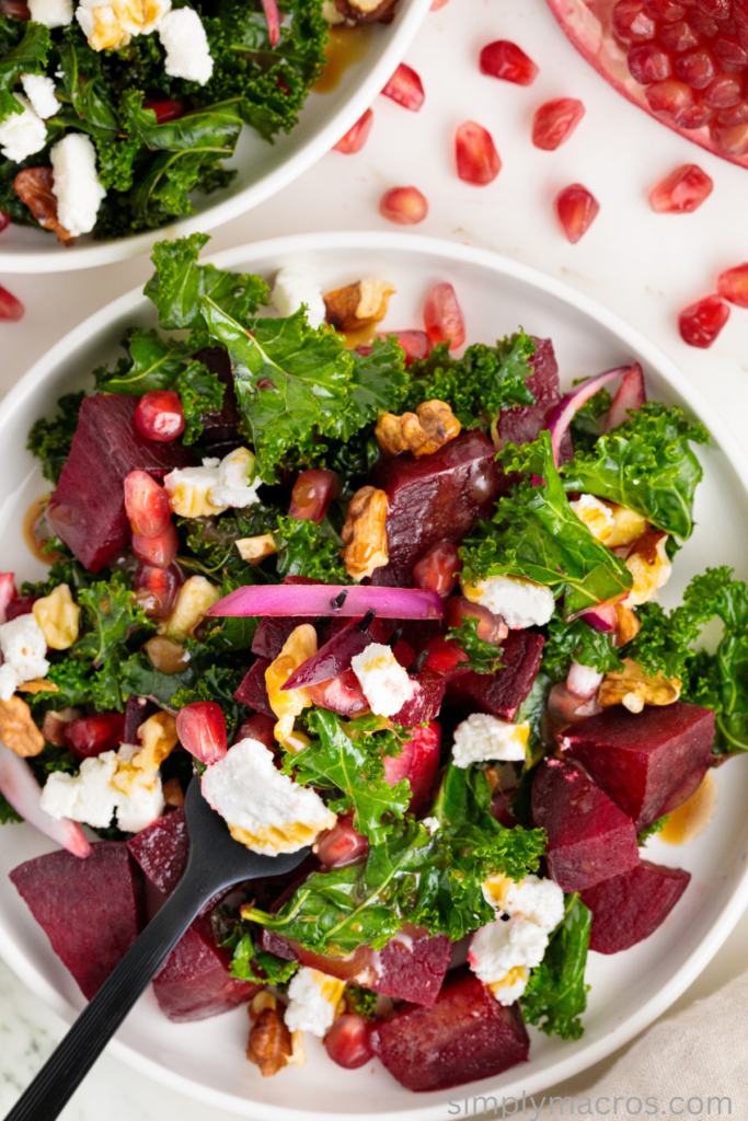 Kale and beet salad, ready to eat with a fork in the center of the plate.