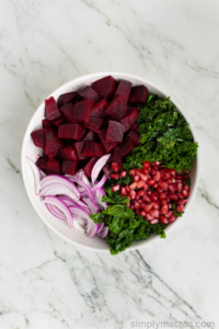 beets, onion, pomegranate, and kale in a bowl.
