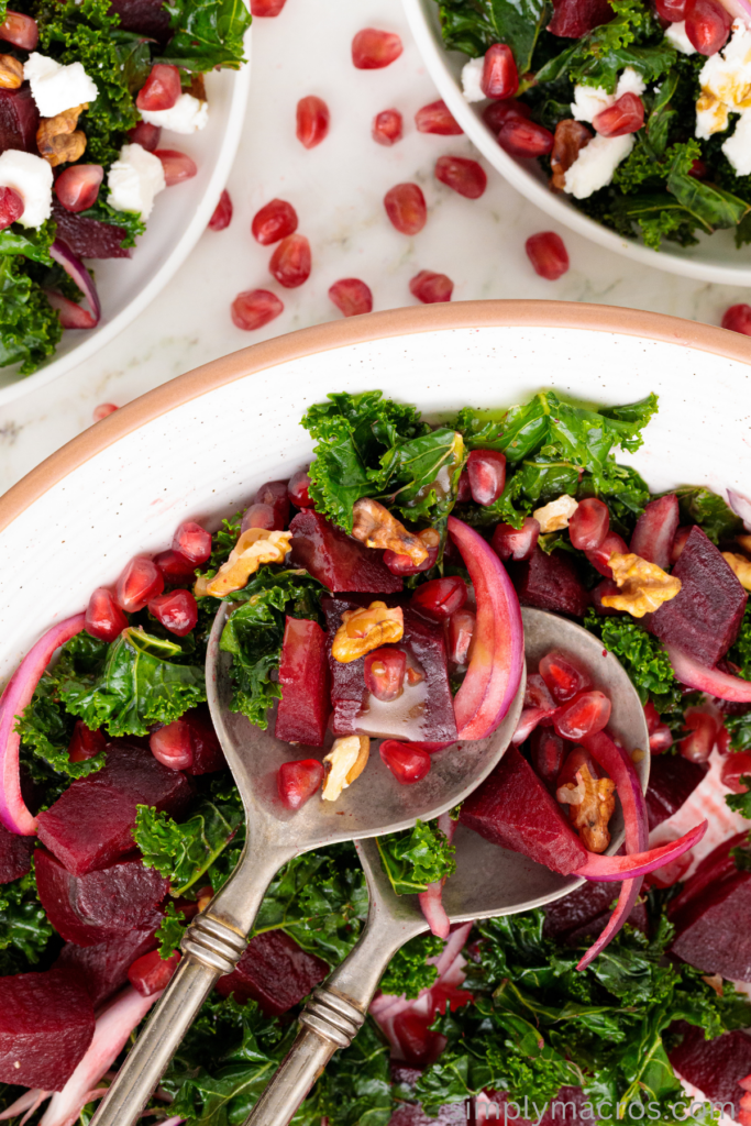 Two salad spoons in the beet and kale salad. 
