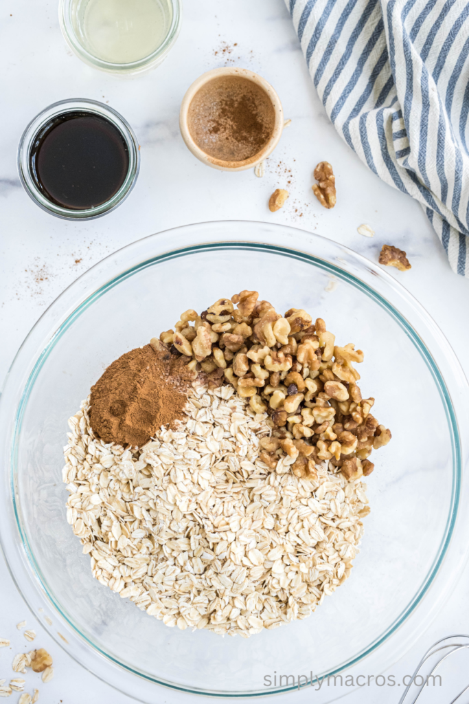 Oats, cinnamon, and walnuts mixed together in a bowl. 