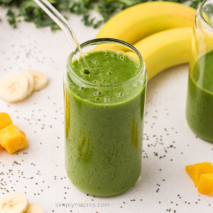 Green kale smoothie in a glass, ready to drink.