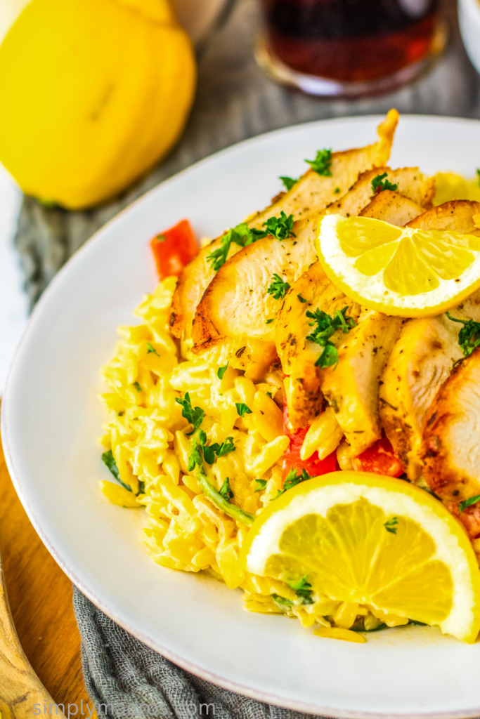 Close up photo of lemon chicken orzo on a white plate. 