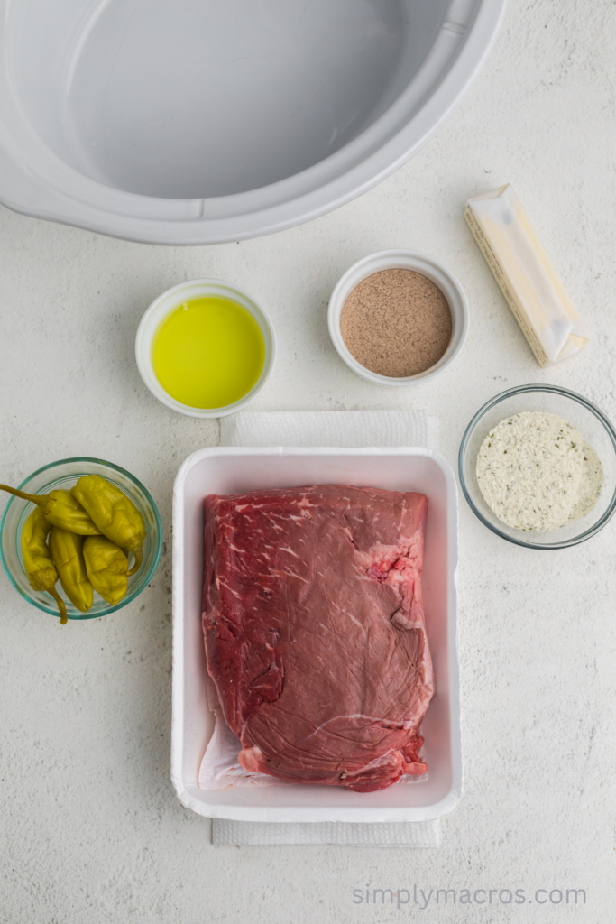 Ingredients to make a pot roast with pepperoncini peppers, butter, and seasonings. 