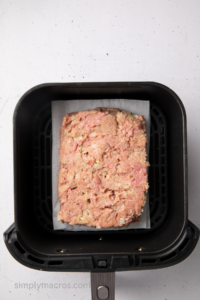 Meatloaf mixture in the basket of the air fryer.