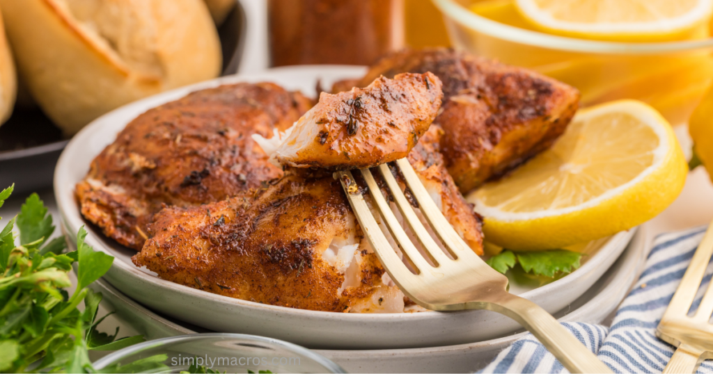 pan fried grouper on a plate with a bite of the fish on a fork.