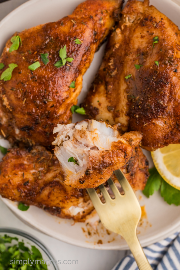 Close up of blackened pan fried grouper filets on a plate with a fork taking a bite. 