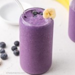 Overhead photo of a banana blueberry smoothie in a glass.
