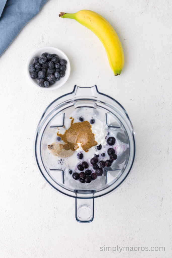 Ingredients in a blender used to make a blueberry banana smoothie.