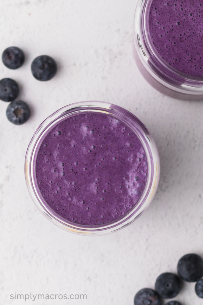 Overhead photo looking down into a blueberry banana smoothie in a glass. 
