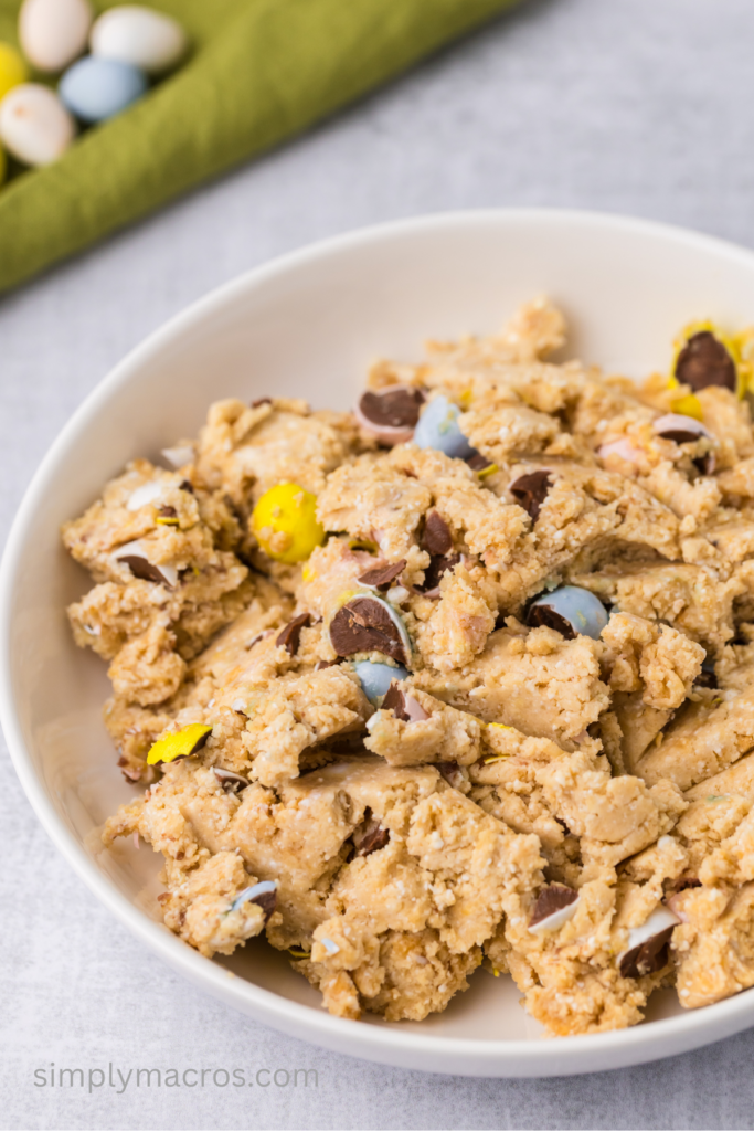 Protein cookie dough in a bowl with chopped Cadbury eggs mixed in. 