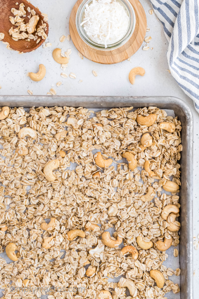 Granola spread on a baking sheet ready to bake. 
