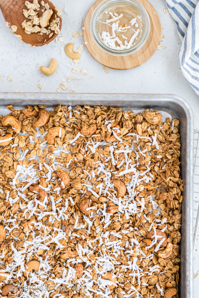 Shredded coconut sprinkled over the granola to be baked.