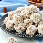 Healthy raw coconut almond bites on a plate and ready to serve.