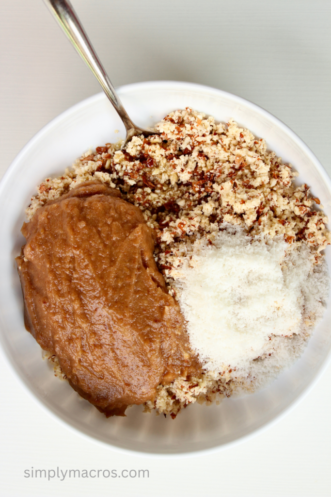 Dates, almonds, banana, and coconut being mixed in a bowl. 