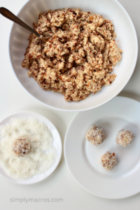 Mixture being rolled into balls and then dipped into coconut flakes.