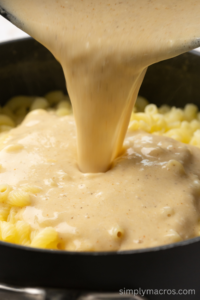 Sauce being poured over the cooked pasta.