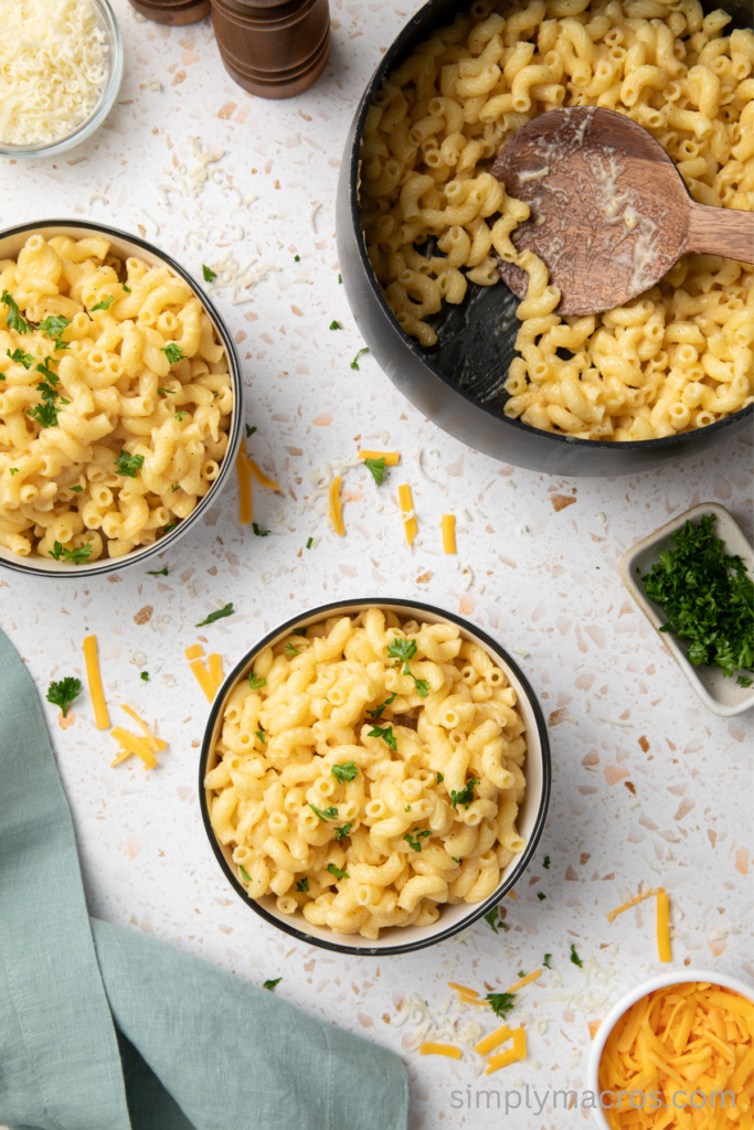 Cottage cheese mac and cheese in bowls and topped with fresh chopped parsley.