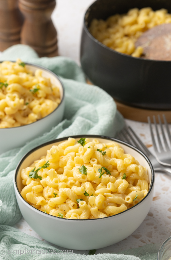 Close up of cottage cheese mac and cheese in a bowl and garnished with fresh parsley.