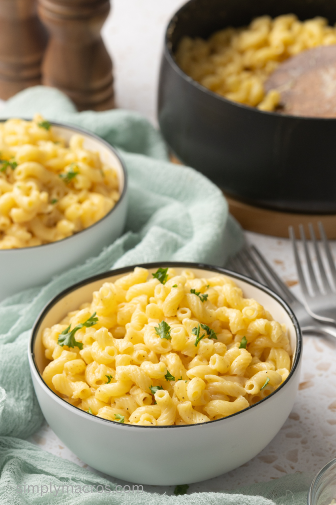 Close up of cottage cheese mac and cheese in a bowl and topped with fresh parsley.