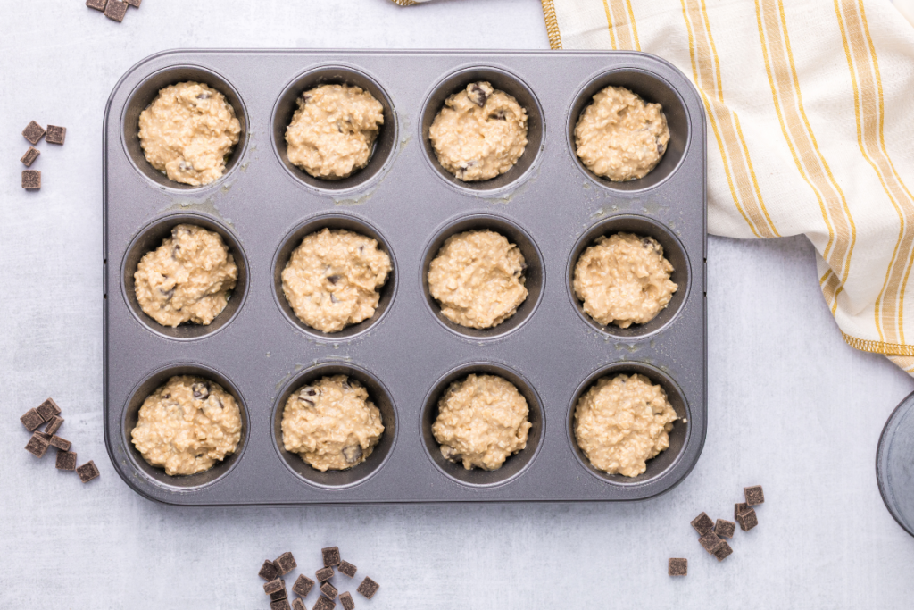 Batter scooped into a muffin tin. 
