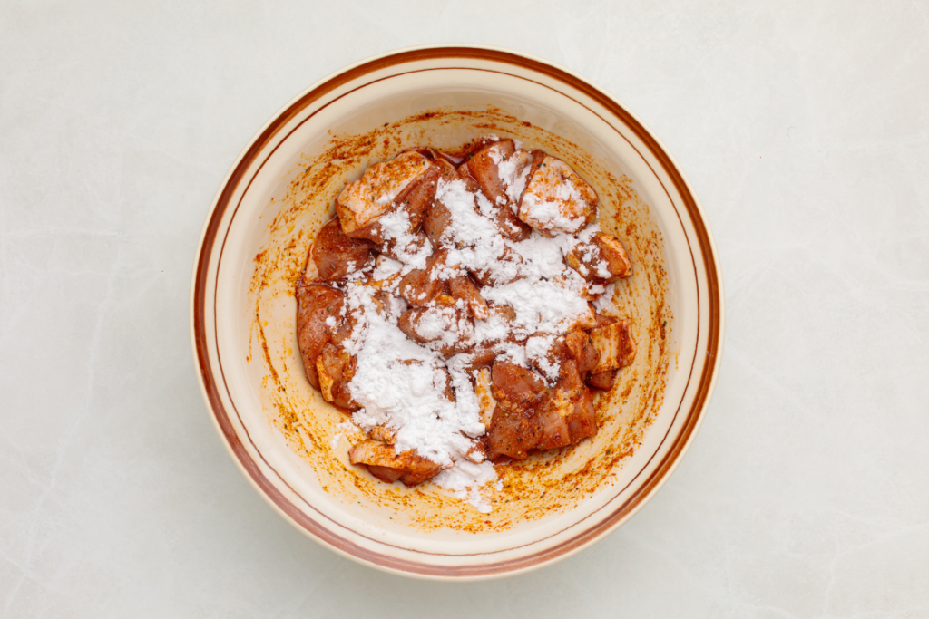 Potato starch poured over marinated chicken.