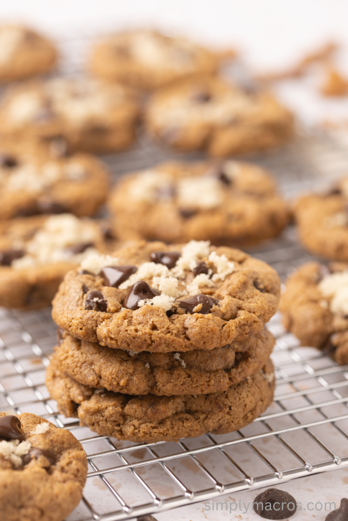 Close up of almond butter chocolate chip cookies stacked on a cooling rack.