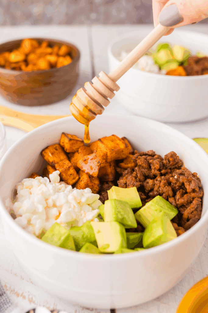 Ground beef bowl being drizzled with hot honey before serving. 