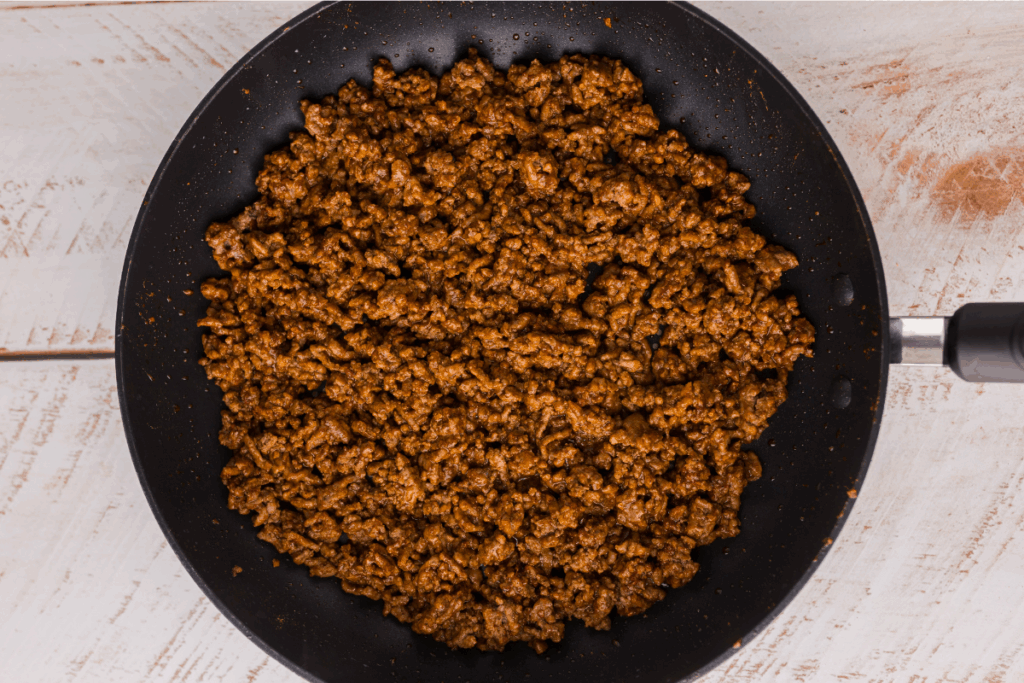 Ground beef fully cooked in a skillet.