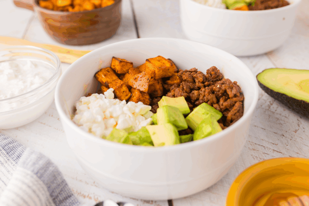 Bowl with taco seasoned ground beef, avocado, sweet potatoes, and cottage cheese. 