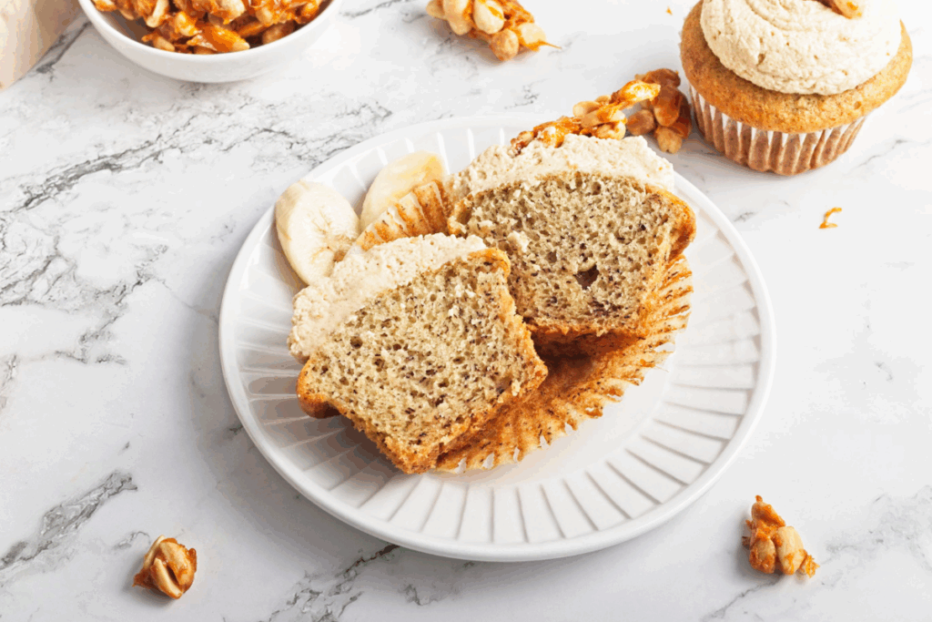 Peanut butter banana cupcake sliced in half and served on a plate.