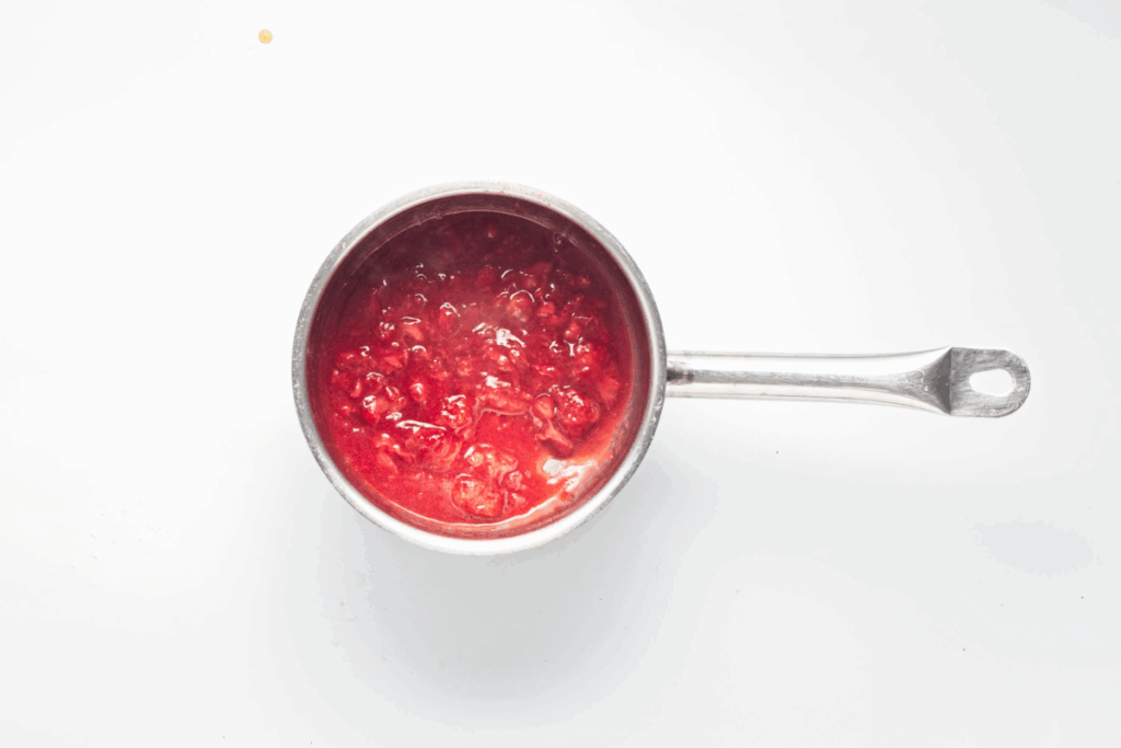 Strawberries and maple syrup in a saucepan. 