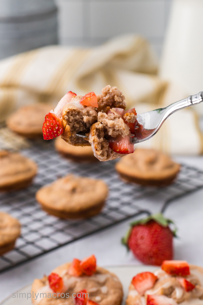 Bite on a fork of muffin with strawberries. 