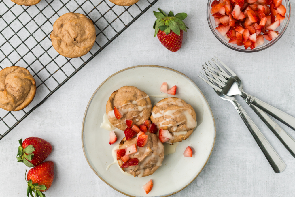 Strawberry cottage cheese muffins topped with a glaze and chopped strawberries.