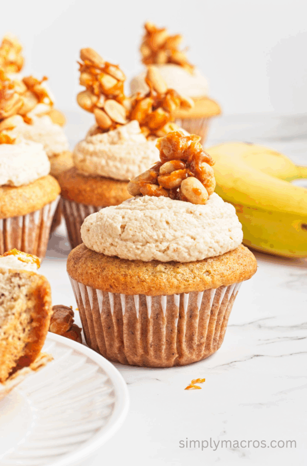 Vegan peanut butter banana cupcakes topped with frosting and peanut brittle.