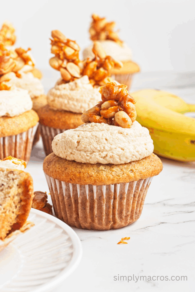 Peanut butter banana cupcake topped with frosting and peanut brittle on top.