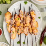 bang bang chicken skewers on a plate ready to eat.