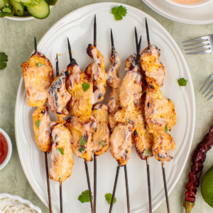 bang bang chicken skewers on a plate ready to eat.