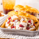 Cranberry pecan chicken salad on a croissant and on a tray ready to serve.