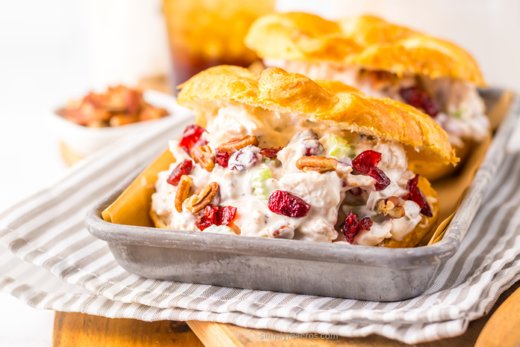 Pecan cranberry chicken salad on a croissant and on a tray ready to serve. 