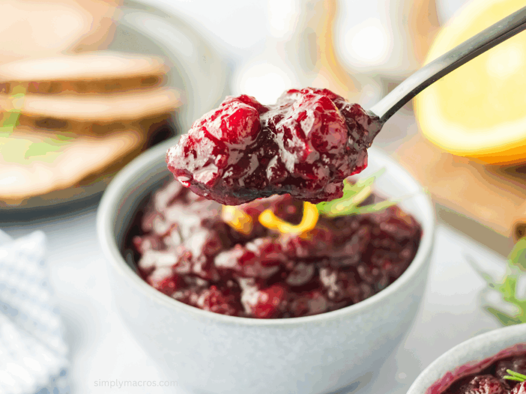 Cranberry sauce in a bowl with a spoon scooping som for serving.