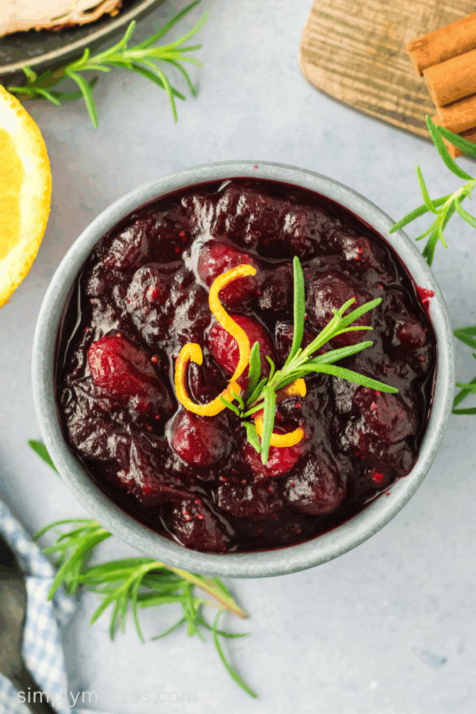 Cranberry sauce in a serving dish and topped with fresh garnish.
