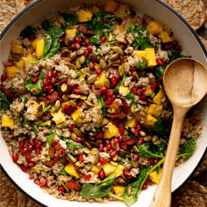 One pot turkey quinoa skillet with butternut squash with a wooden serving spoon.