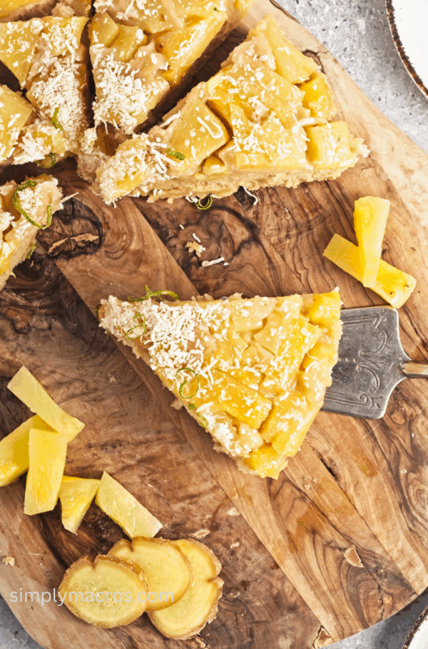 Slice of vegan pineapple upside down cake on a cutting board, ready to serve.