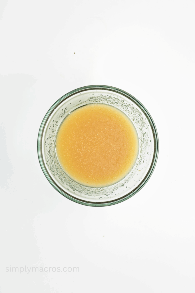 Applesauce, maple syrup, and oil mixed together in a large bowl.