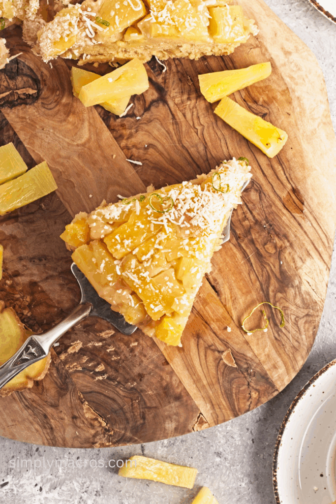 A slice of a vegan pineapple upside down cake on a cutting board, ready to serve.